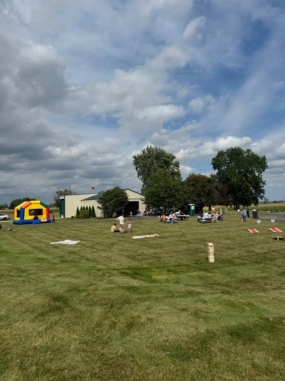Families gather on an open lawn for A Day of Hope in the United States, with a bounce house, lawn games, and picnic tables.